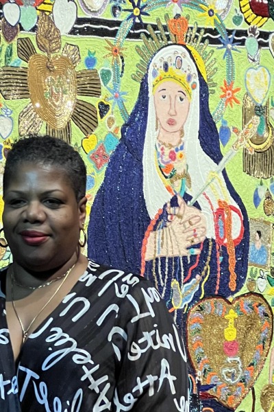 Petrouchka Moïse standing in front of the Waterloo Center for the Art's “Ezili Freda” at the Fowler Museum at UCLA exhibition “Myrlande Constant: Works of Radiance.”