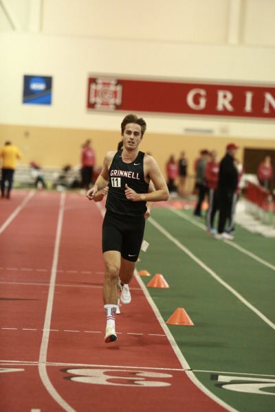 A young man runs on the indoor track 