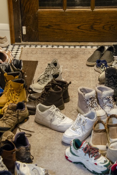 Twenty-some pairs of shoes in an entryway
