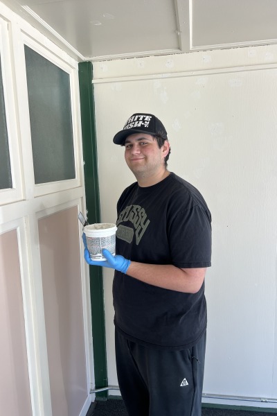 Max Waldman ’29 wearing black and holding a white container