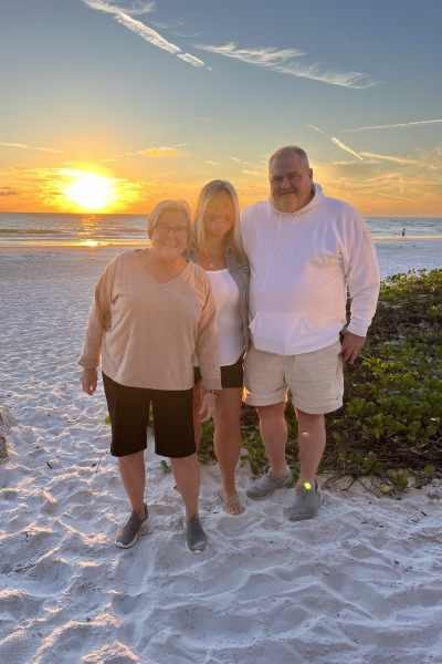 3 people on beach during sunset